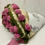 Handwoven Baby Blanket Bouquet Cream and pink crochet baby blanket folded to look like a flower bouquet